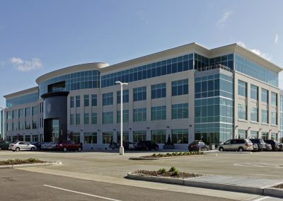 Modern office building with glass windows and a large parking lot — Acendex headquarters located at 3333 Richmond Rd, Beachwood, Ohio.